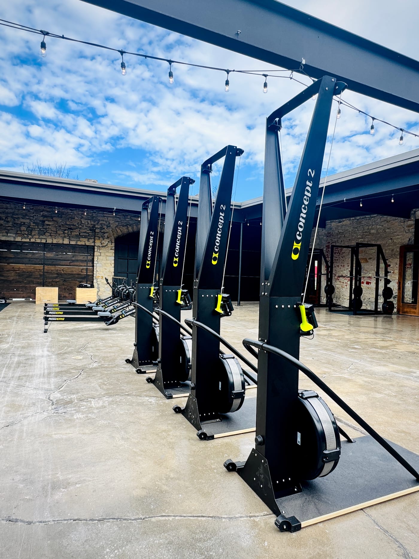 Official HYROX race equipment — Concept2 SkiErgs and rowers lined up in the SOULRNR courtyard in Jefferson City
