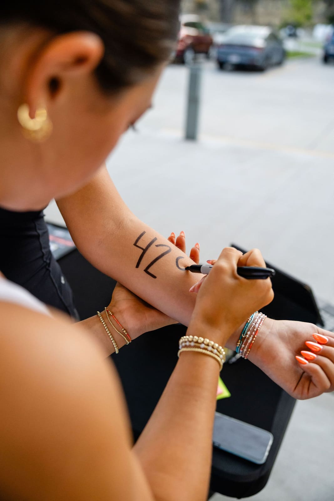 An athlete's number written on her arm at check-in