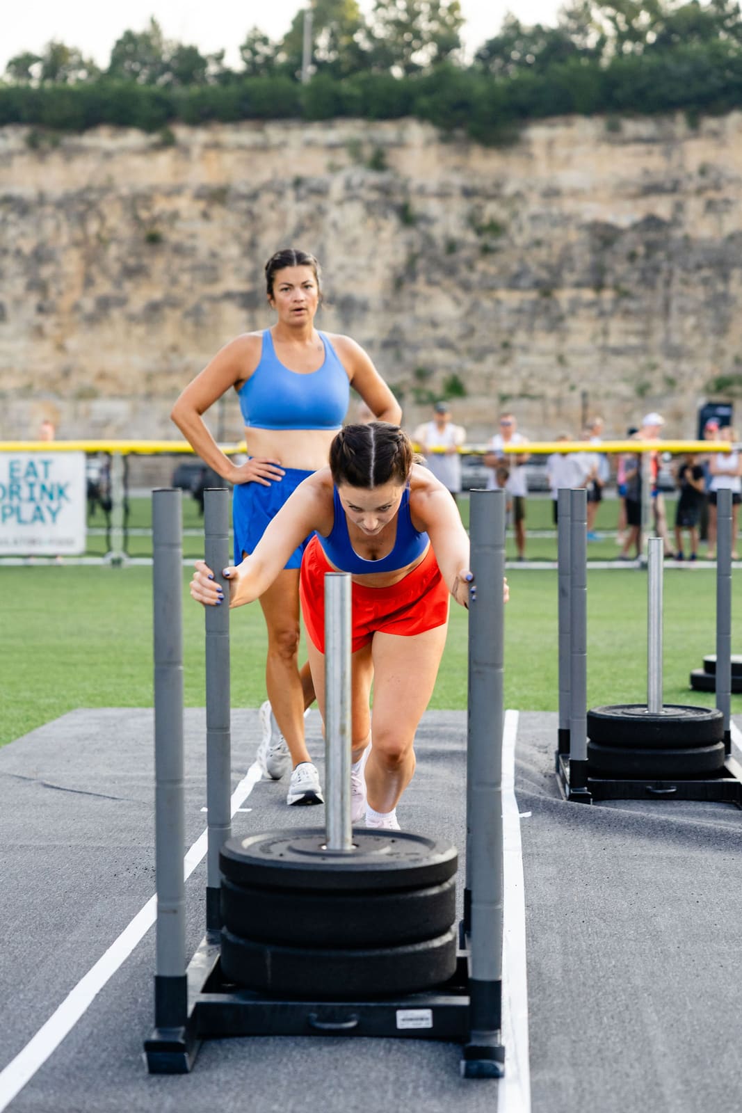 Two athletes pushing sleds side by side