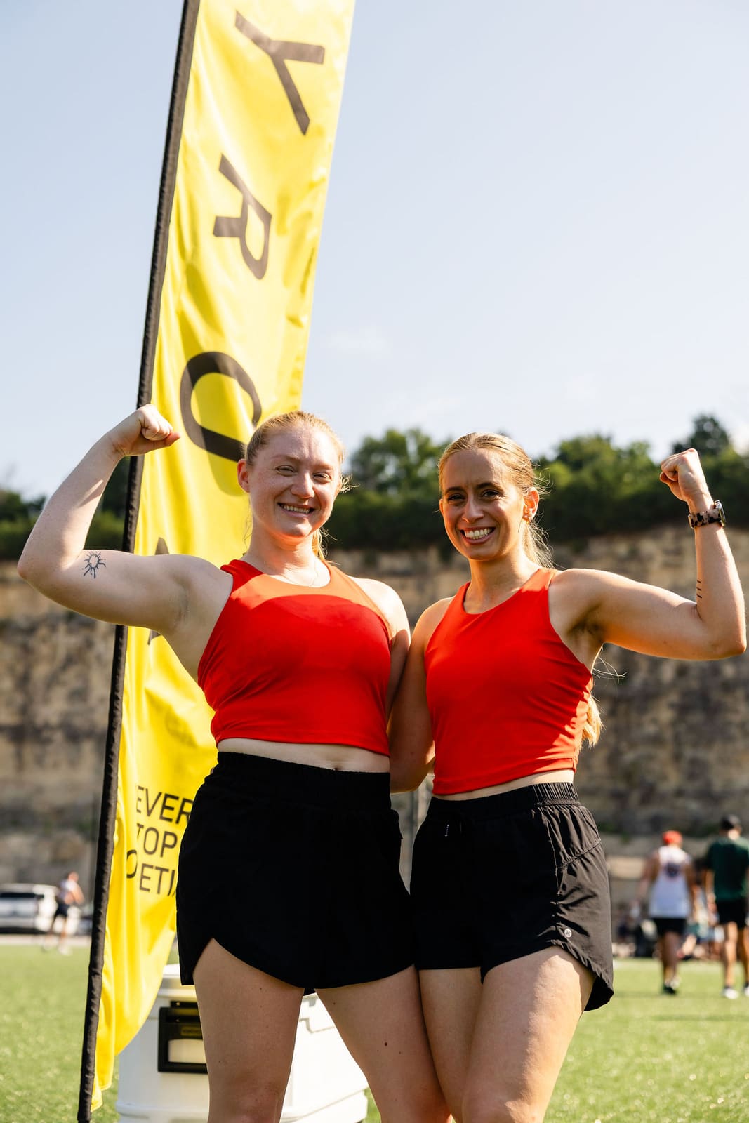 Two athletes flexing and smiling after the race